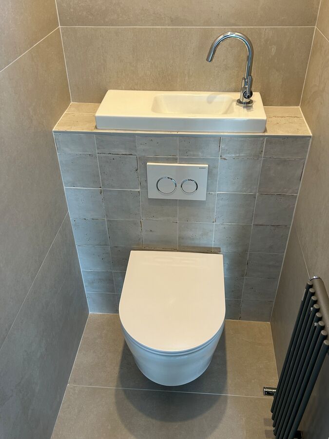 Une salle de bain avec WC, lavabo et radiateur.