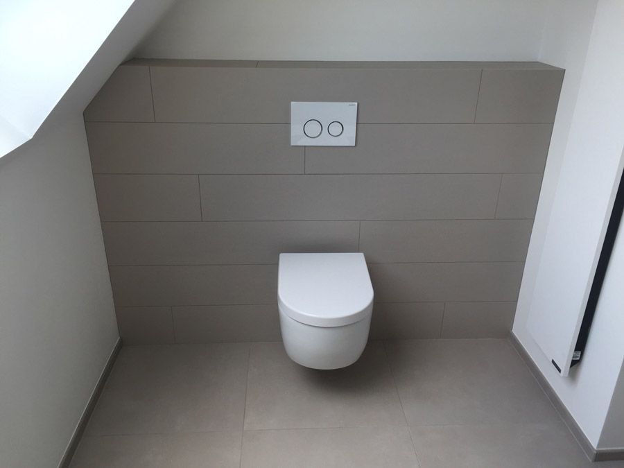 Une toilette est suspendue au mur dans une salle de bain.