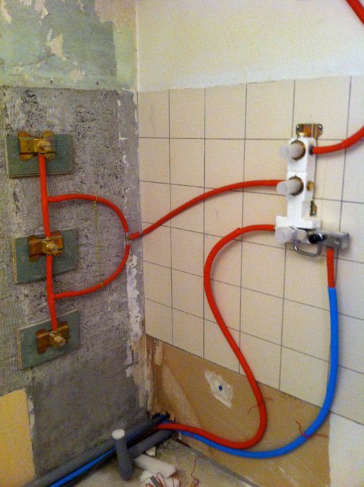 Un tas de tuyaux sont reliés à un mur