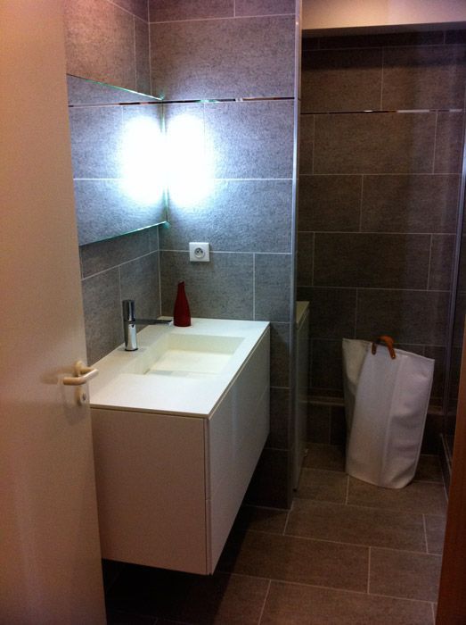 Une salle de bain avec un lavabo, un miroir et un panier à linge.