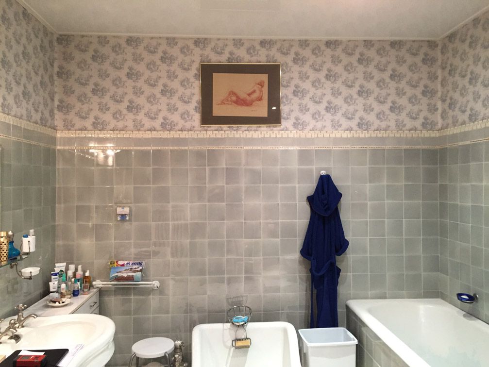 Une salle de bain avec un tableau sur le mur au-dessus de la baignoire
