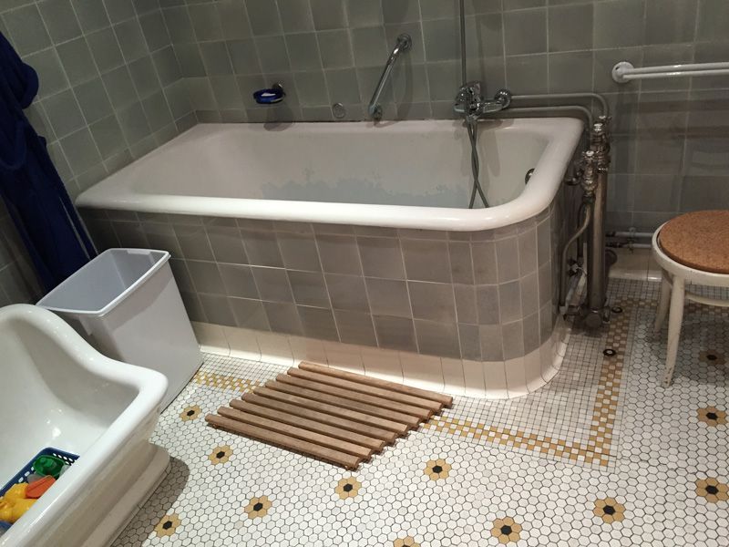 Une salle de bain avec une baignoire et une poubelle