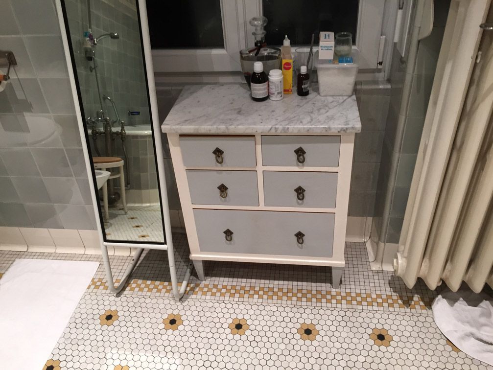 Une salle de bain avec une commode et un miroir.