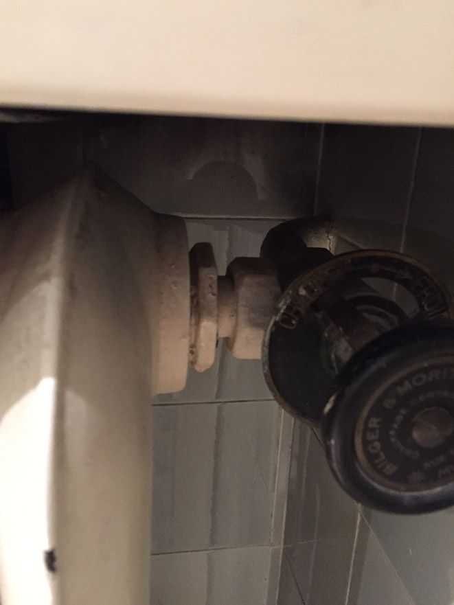 Un gros plan d'une valve sur une toilette dans une salle de bain.