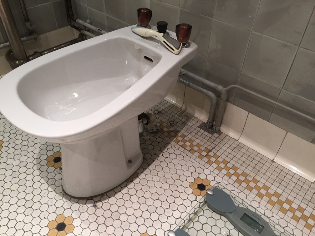 Une salle de bain avec un bidet et une balance au sol