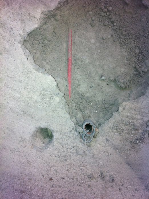 Un trou dans le sol avec une ligne rouge qui le traverse.