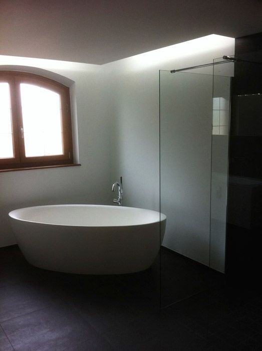 Une baignoire dans une salle de bain à côté d'une fenêtre