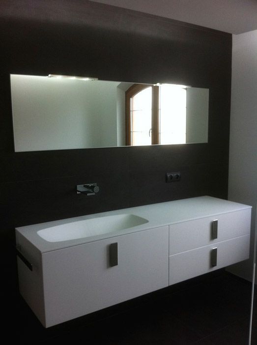 Une salle de bain avec un lavabo et un grand miroir