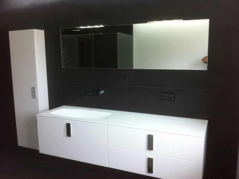 Une salle de bain avec des armoires blanches et un grand miroir