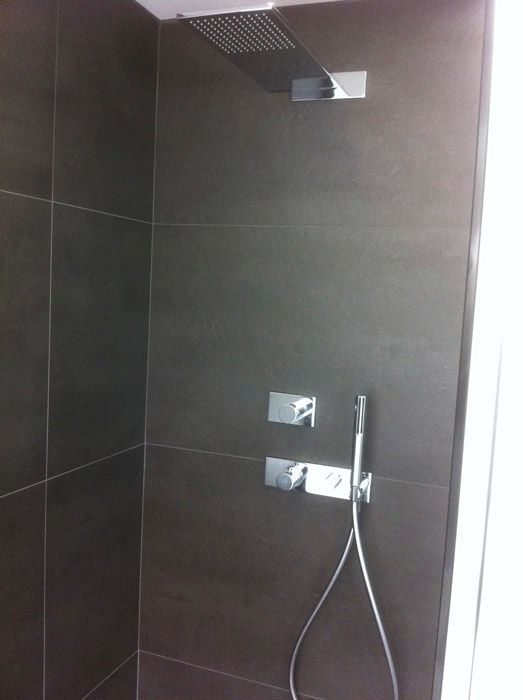 Une douche avec une pomme de douche et un tuyau