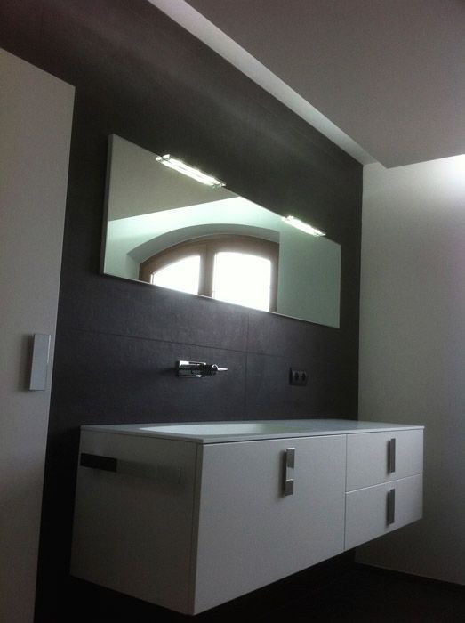 Une salle de bain avec un lavabo et un grand miroir