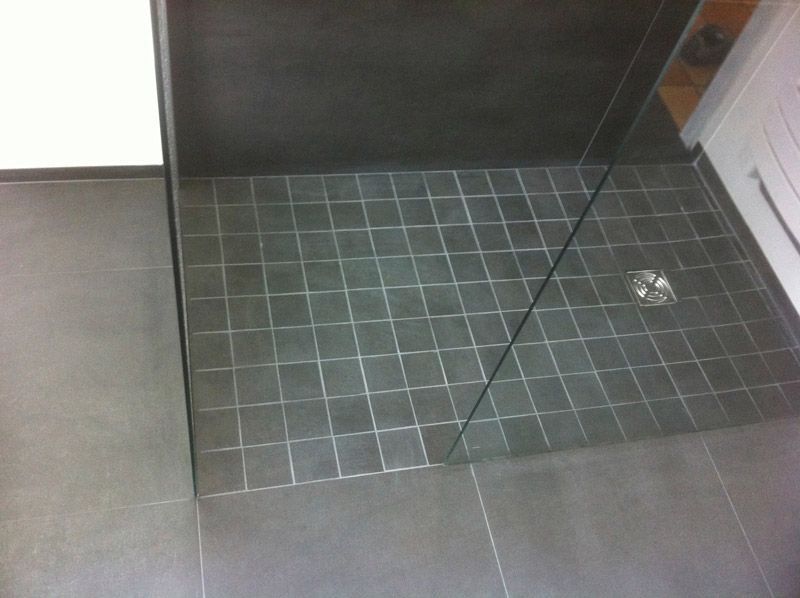 Une salle de bain avec douche à l'italienne et sol carrelé