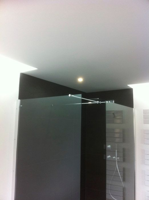 Une salle de bain avec douche à l'italienne et un plafonnier.