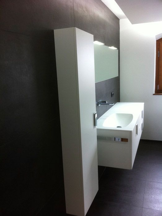 Une salle de bain avec un lavabo et un miroir au mur