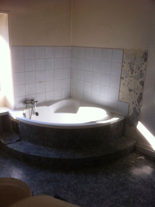 Une salle de bain avec une grande baignoire dans le coin