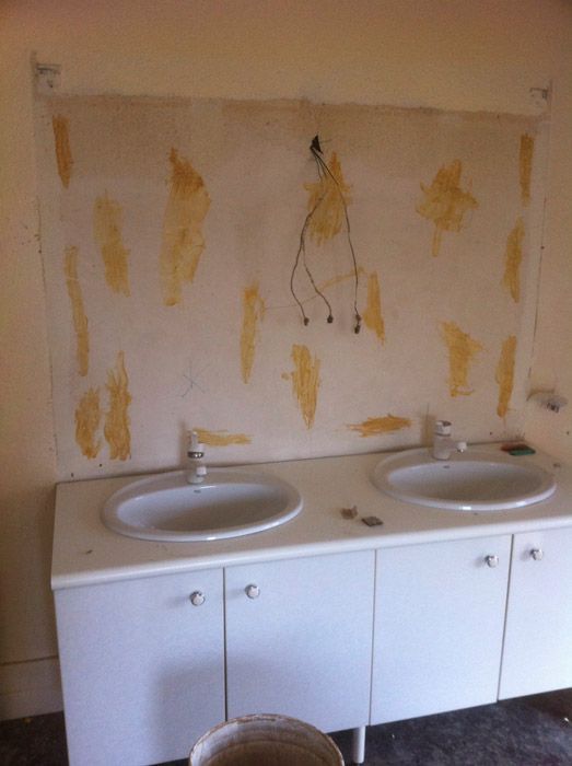 Une salle de bain avec deux lavabos et un seau de peinture