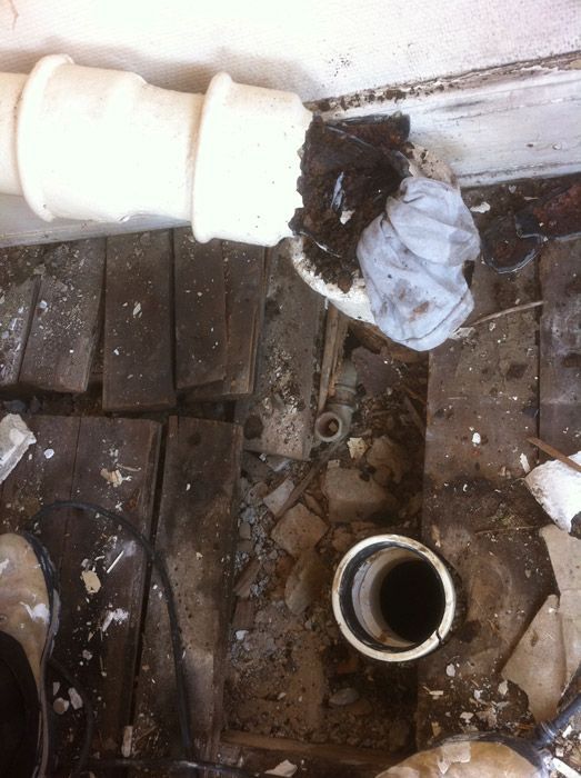 Un tuyau est retiré d'un plancher en bois