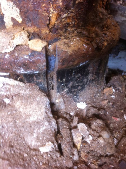 Un gros plan d'un tuyau rouillé dans le sol.