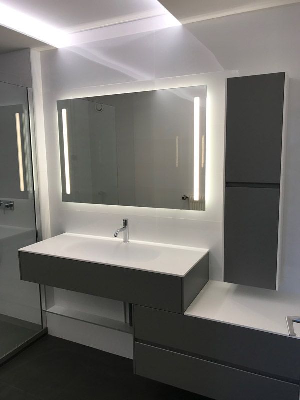 Une salle de bain avec un lavabo, un miroir et des armoires.