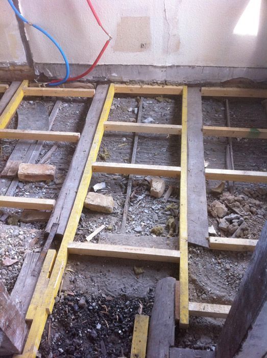 Une échelle en bois est posée sur un sol en béton