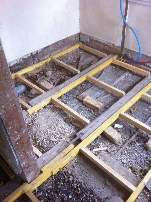 Un plancher en bois est en cours de construction dans une pièce