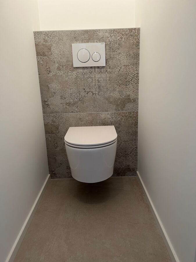 Une toilette est suspendue au mur dans une salle de bain.