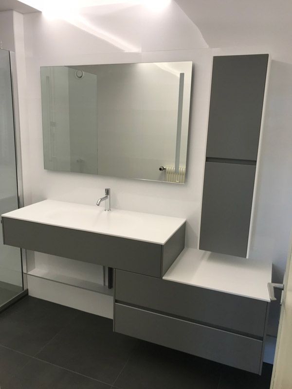 Une salle de bain avec un lavabo, un miroir et des armoires