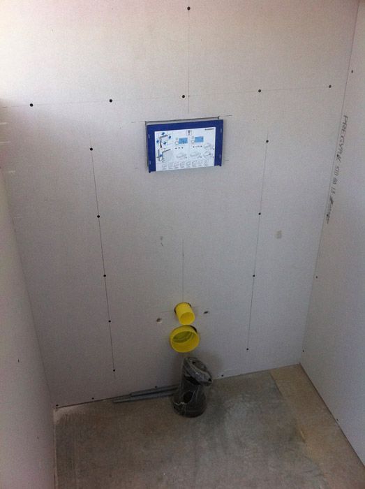 Une salle de bain est en cours de rénovation avec des toilettes suspendues.