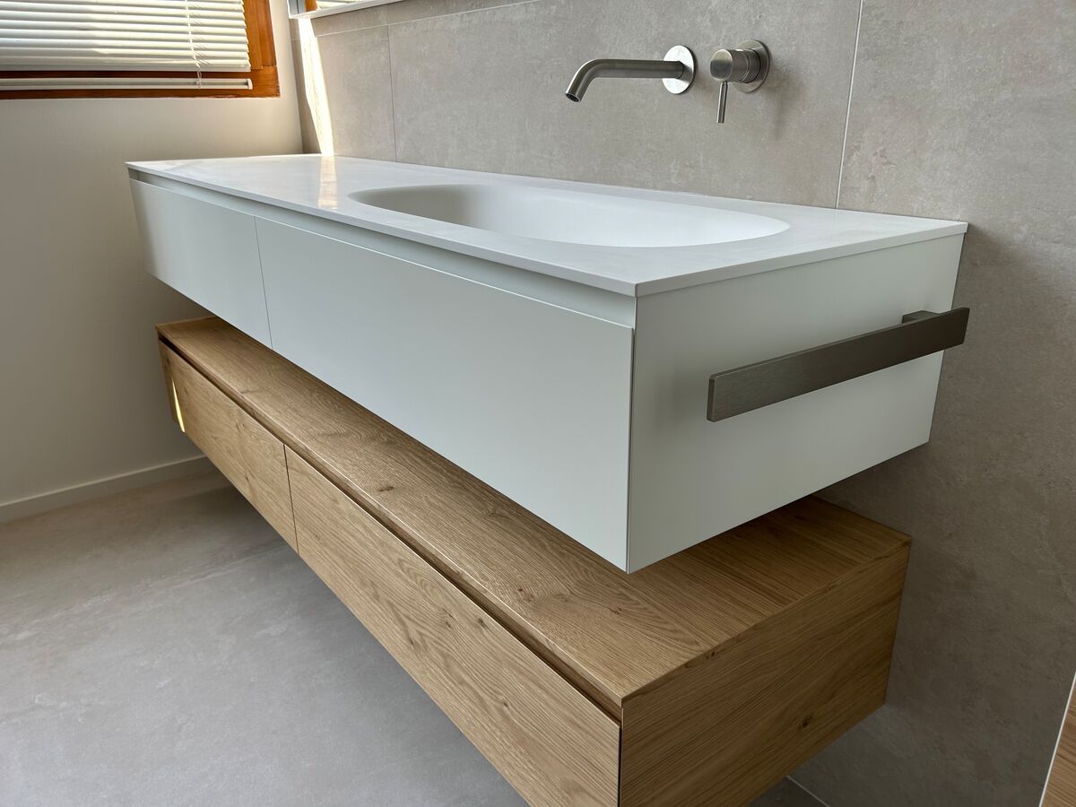 Un lavabo de salle de bain avec une étagère en bois en dessous.