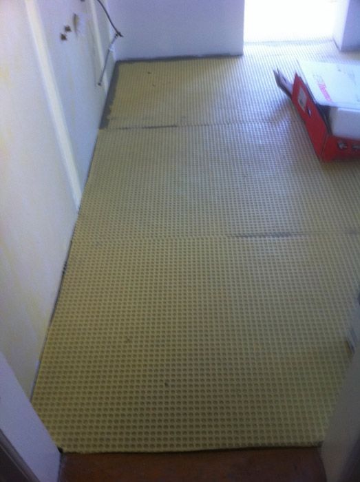 Une pièce avec un sol en carrelage jaune et une boîte rouge sur le sol.