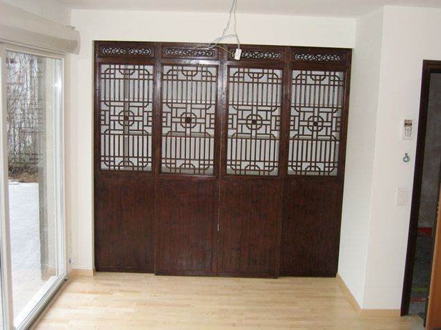 Une pièce avec une porte coulissante en verre et des portes en bois