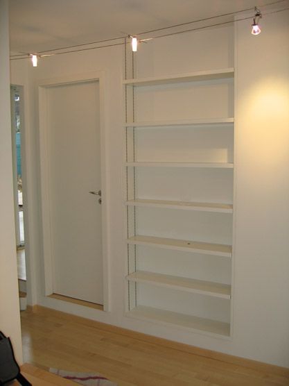 Une pièce avec une porte et des étagères à l'intérieur