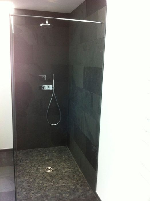 Une salle de bain avec douche à l'italienne et pommeau de douche.