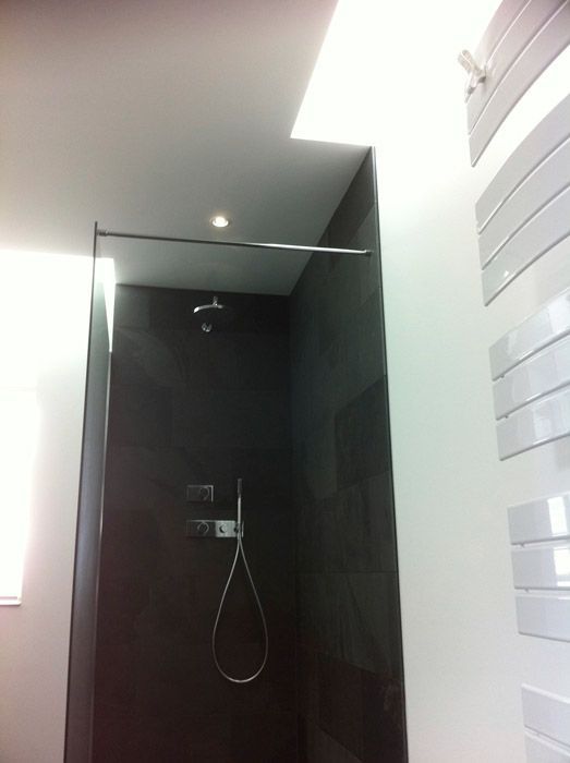 Une salle de bain avec une douche à l'italienne et un porte-serviettes blanc