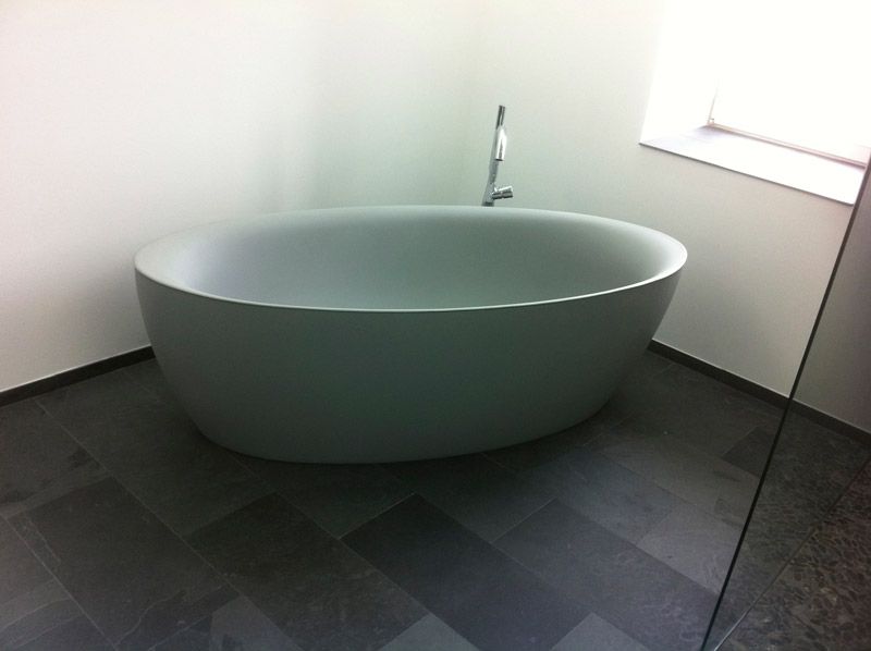 Une baignoire dans une salle de bain à côté d'une fenêtre