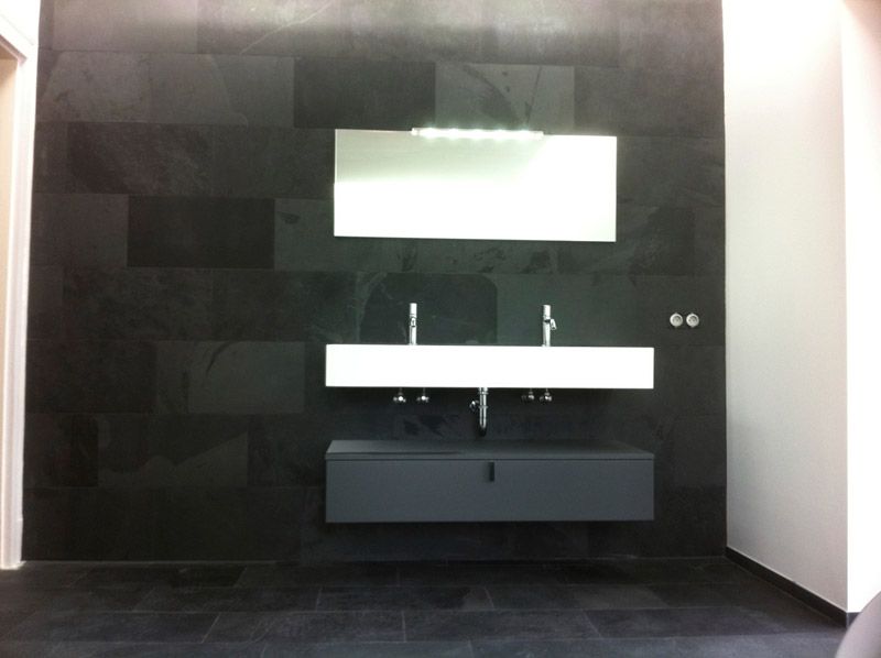 Une salle de bain avec deux lavabos et un miroir