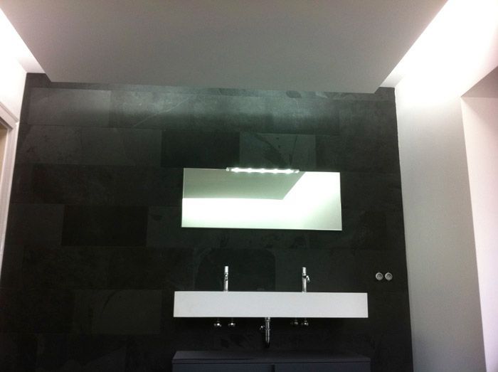 Une salle de bain avec deux lavabos et un miroir au mur