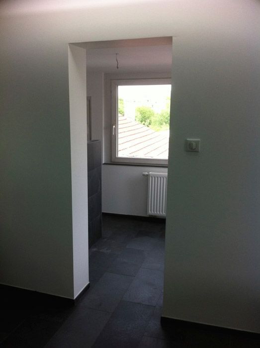 Une pièce vide avec une fenêtre et un radiateur.