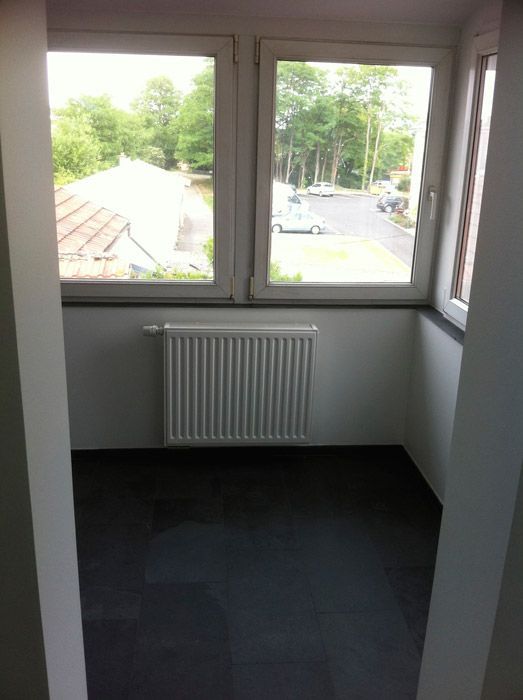 Une pièce vide avec une fenêtre et un radiateur