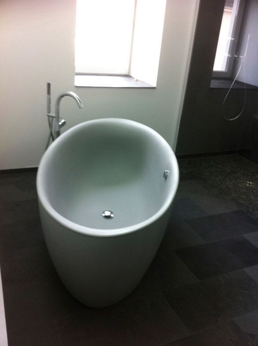 Une baignoire ronde dans une salle de bain à côté d'une fenêtre