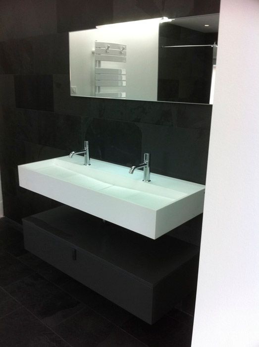 Une salle de bain avec deux lavabos et un miroir