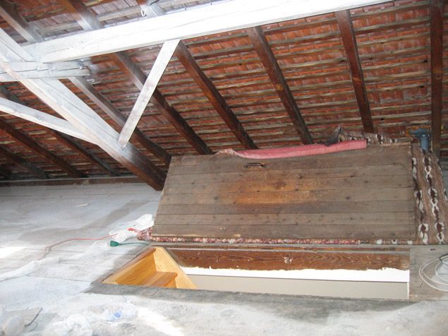 Une boîte en bois est posée sous un toit en briques