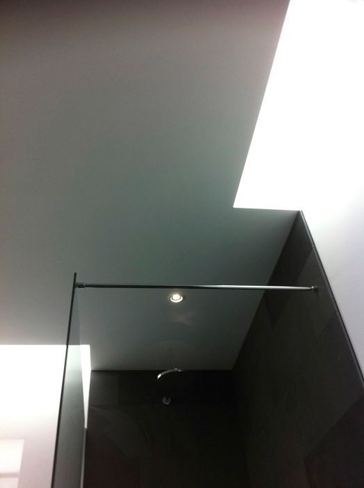 Une salle de bain avec douche à l'italienne et plafond blanc