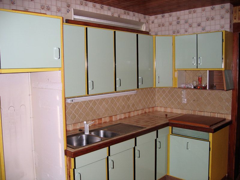 Une cuisine avec des armoires vertes et des garnitures jaunes