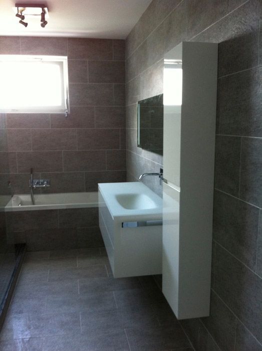 Une salle de bain avec un lavabo, une baignoire et un miroir