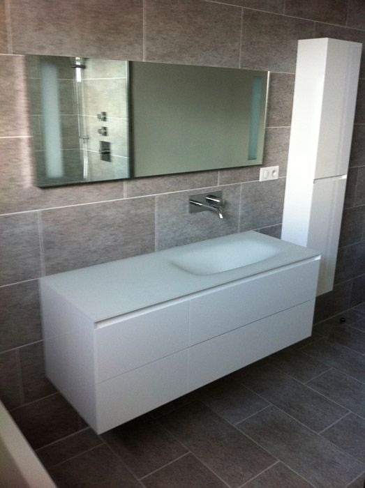 Une salle de bain avec un lavabo et un grand miroir