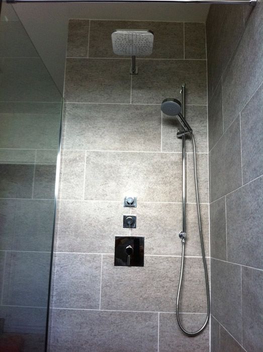 Une pomme de douche est suspendue au plafond dans une salle de bain.