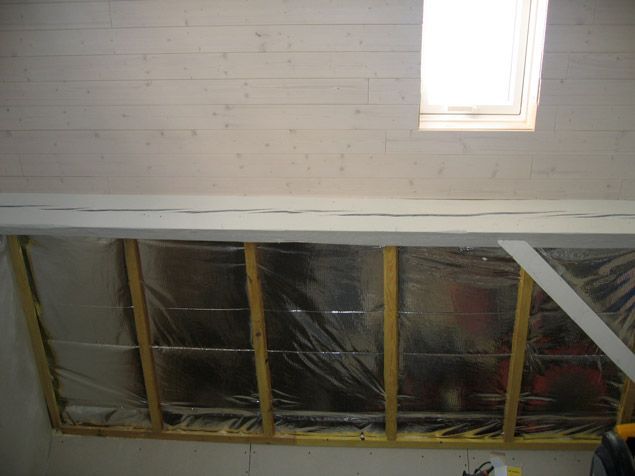 Une pièce avec un plafond en bois et une fenêtre.