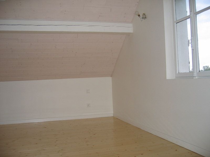 Il y a une fenêtre dans le coin de la pièce.