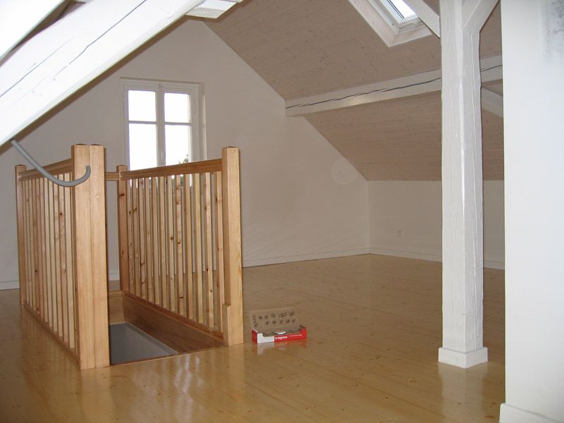 Une pièce vide avec une balustrade en bois et une fenêtre